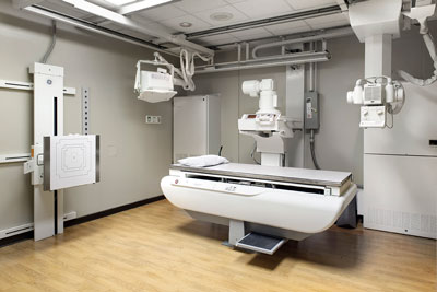 Picture of Nuclear Medicine Imaging. It is a medical table bed with a pillow on top of it with different Imaging equipment